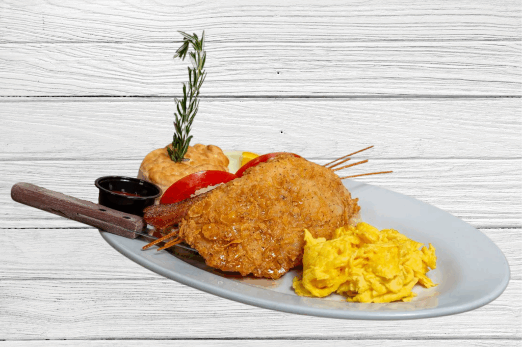 Dining with a View: Enjoying Hash House A Go Go at The Plaza 1 A flavorful view of Hash House A Go Go’s fried chicken and eggs plate, served with a biscuit, scrambled eggs, tomato, bacon, and syrup on the side.
