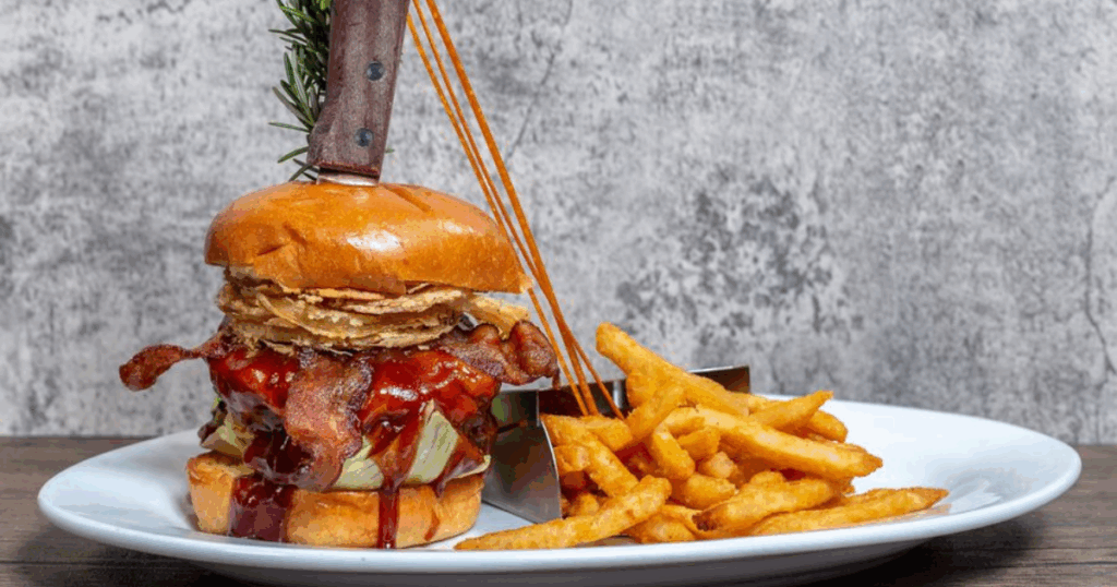 The Best Comfort Food Near the Strip: A Guide to Hash House A Go Go’s Unique Eats 1 Stuffed burger with melted cheese, crispy fries, and twisted toppings—comfort food perfection at Hash House A Go Go near the Strip.