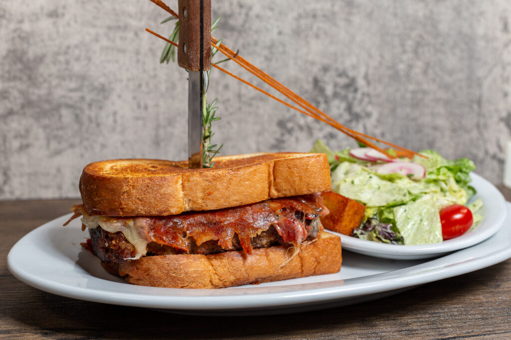 The Kokomo sandwich bursting with flavor at Hash House A Go Go Plaza—griddled meatloaf with mozzarella and roasted tomato on old-fashioned milk bread in Downtown Las Vegas