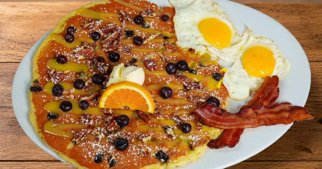 Blueberry Pecan & Lemon Glaze Flapjack with blueberries, candied pecans, eggs and bacon at Hash House A Go Go at the Plaza Las Vegas